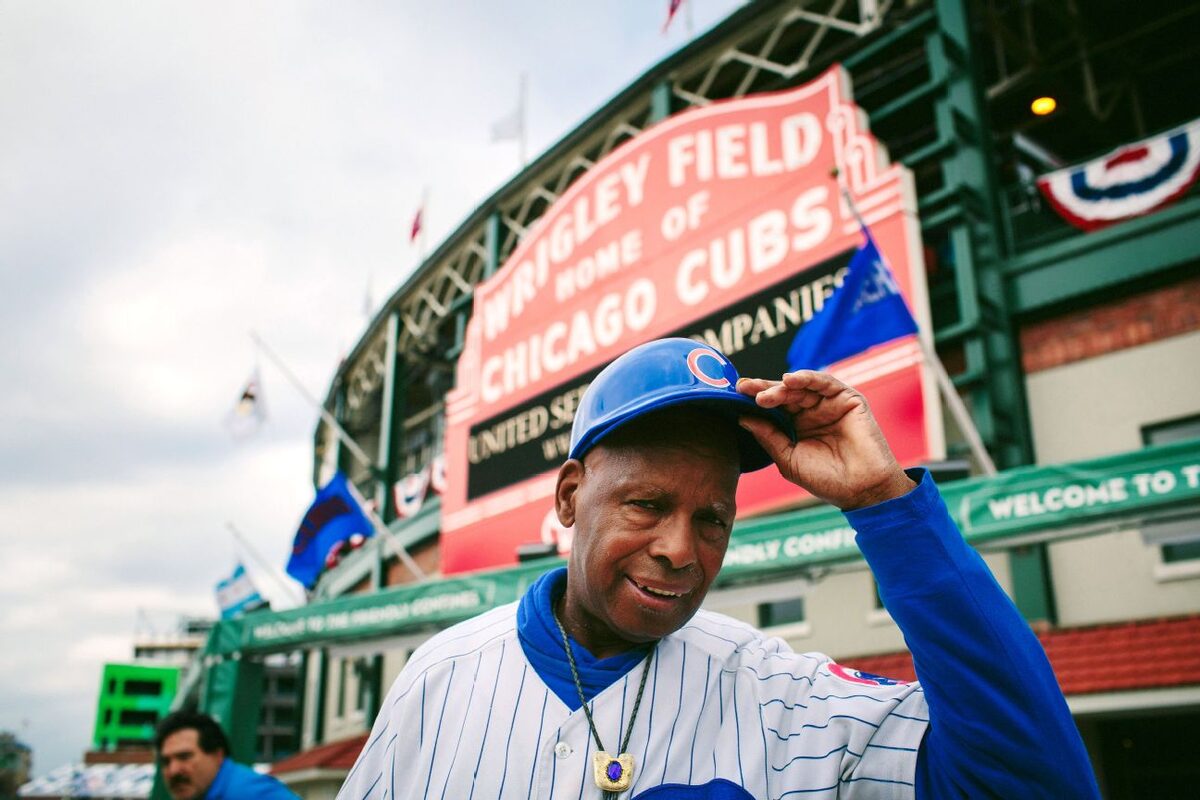Cubs superfan Ronnie Woo-Woo Wickers tipping his cap in front of the Wrigley Field marquee